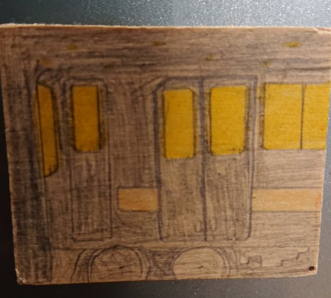 木のプレートで作ったマグネットに描かれているのは、窓から光を漏らしながら暗闇を駆ける、赤いラインの入った電車